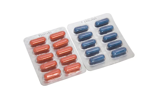 Два волдыря с красными и синими таблетками — стоковое фото