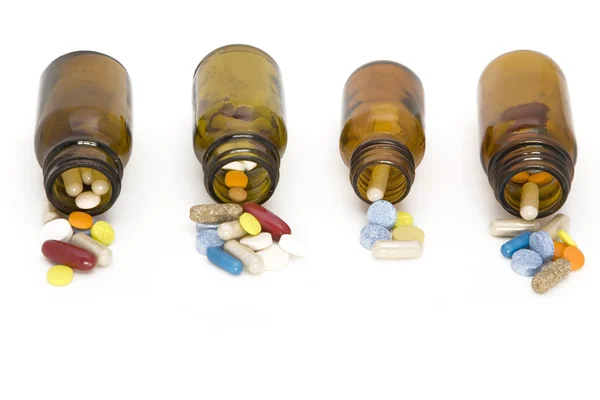 Fluxo colorido de comprimidos provenientes de garrafas de comprimidos — Fotografia de Stock