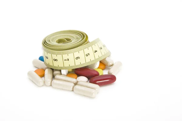 Ruban à mesurer et pilules — Photo