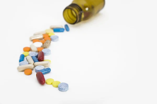 Fluxo colorido de pílulas provenientes de uma garrafa de pílula — Fotografia de Stock