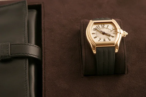 Relógio de ouro com pulseira preta — Fotografia de Stock