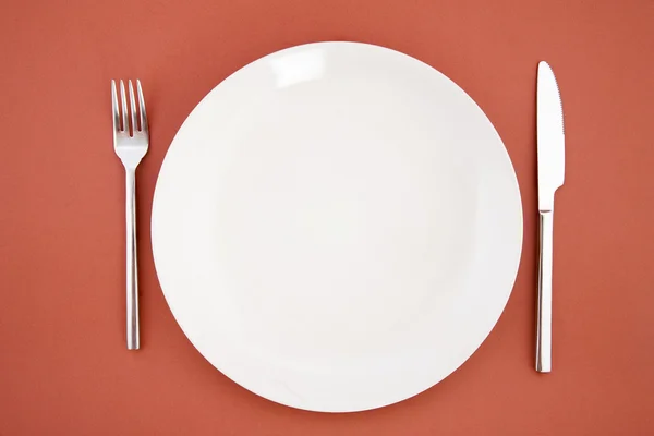 Cuchillo, plato blanco y tenedor — Foto de Stock