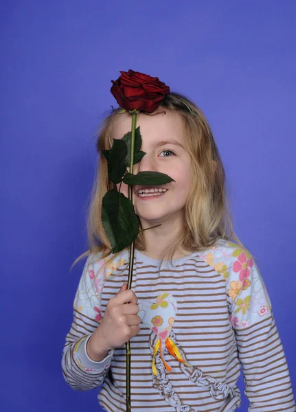 Маленькая девочка с красной розой — стоковое фото