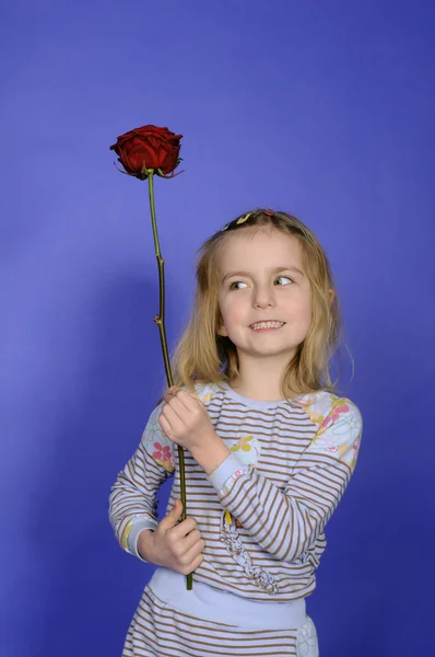 Kleines Mädchen mit roter Rose — Stockfoto