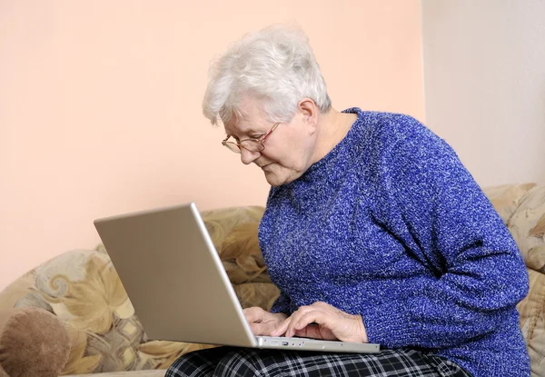 Elderly woman working on laptop — Stock Photo, Image