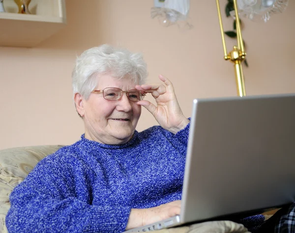 Пожилая женщина работает на ноутбуке — стоковое фото