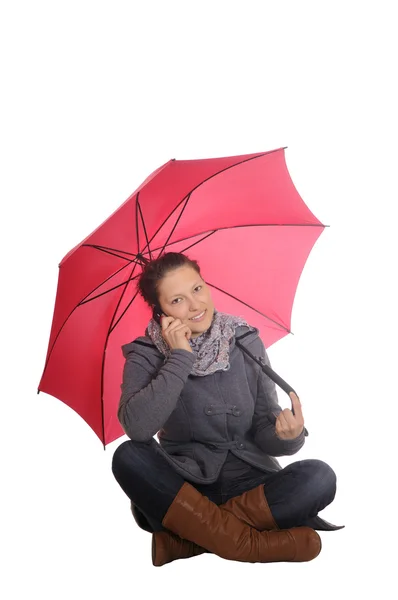 Женщина с мобильным телефоном и зонтиком — стоковое фото