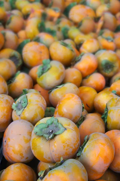 Hög med orange persimoner vertikala — Stockfoto