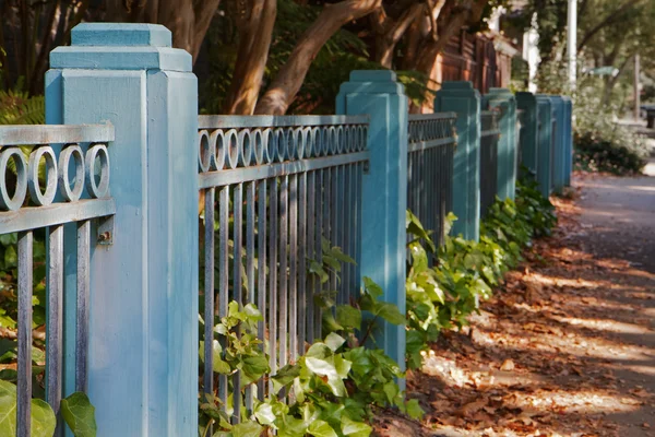 Gehweg mit blauem Zaun — Stockfoto