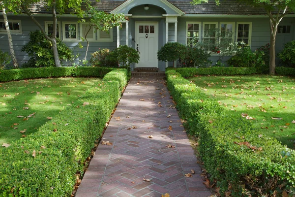 Green bush lined home entrance — Stock Photo, Image