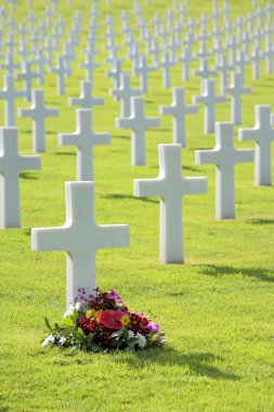 Pretty flowers by grave of unmarked cross headstone clipart