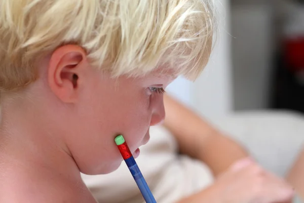 Ung blond gutt gjør lekser med blyant – stockfoto