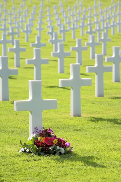 Jolies fleurs par tombe de pierre tombale de croix non marquée — Photo