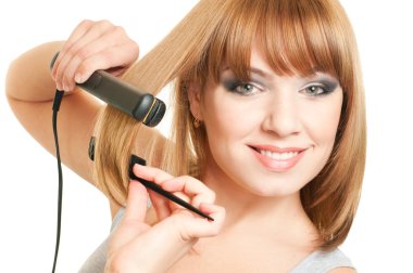 Portrait of beautiful young woman with fashion hairstyle holding crimper and comb clipart