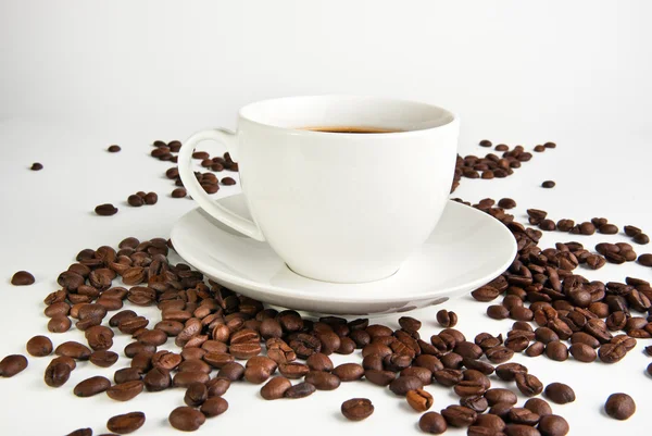 Kaffe kopp och kaffebönor på vit bakgrund — Stockfoto