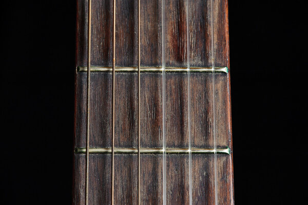 An old classical guitar against a black background