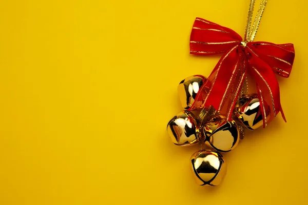 Vánoční zvonky na žlutém podkladu — Stock fotografie