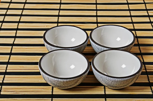 stock image Four cups for tea on a napkin from rice straw