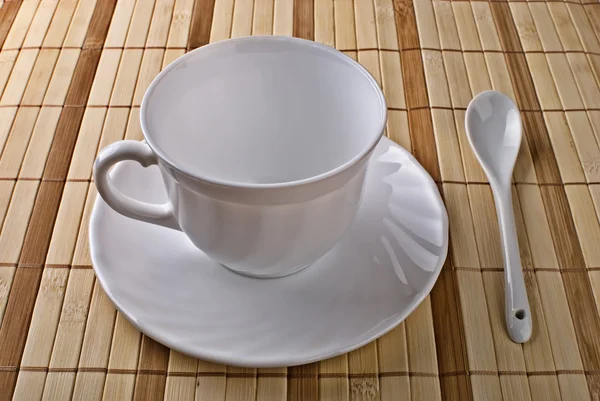 Beyaz fincan, tabak, kaşık pirinç çubuk üzerinden peçete