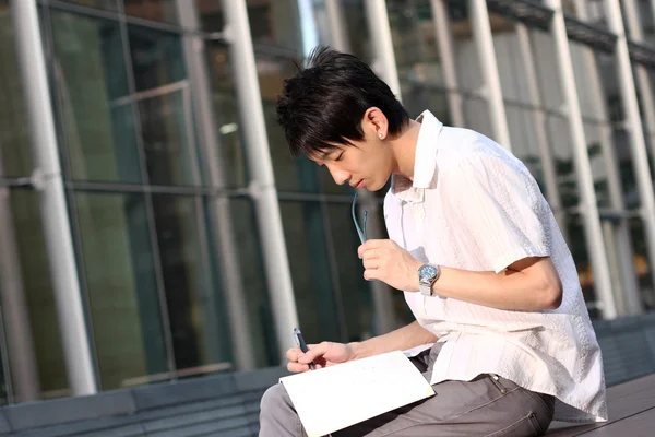 Casual asiático hombre de negocios mensajes de texto en su libro — Foto de Stock
