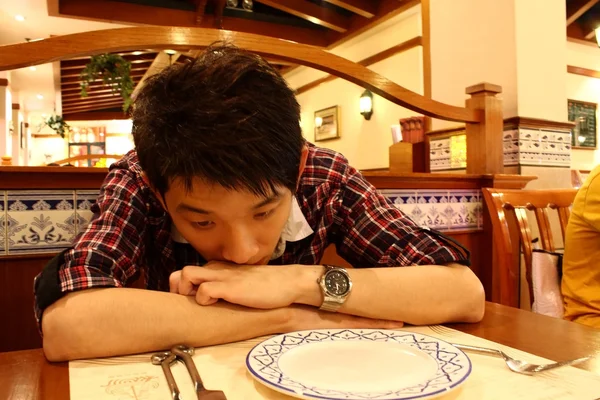 Retrato de un hombre asiático inclinado sobre la mesa —  Fotos de Stock