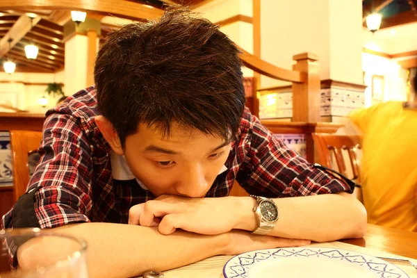 รูปภาพของชายเอเชียที่โค้งบนโต๊ะ — ภาพถ่ายสต็อก