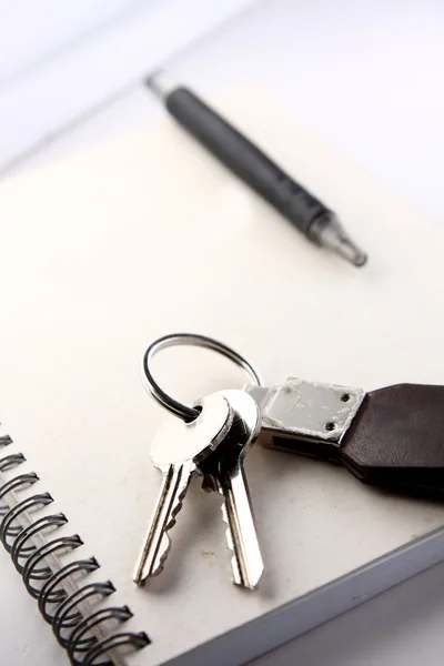 Дневник, ручка и ключи на белом фоне — стоковое фото
