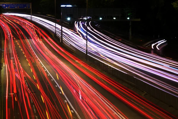 Estrada noturna (Carros em uma corrida movendo-se rapidamente em uma estrada (speedway — Fotografia de Stock