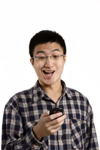 Lässiger Mann lächelt überrascht auf Handy — Stockfoto