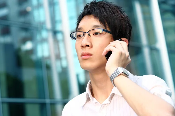 Случайный азиатский бизнесмен разговаривает по мобильному телефону — стоковое фото