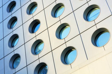 Windows of modern building toned in blue color clipart