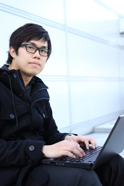 年轻男子在室外工作的一台笔记本电脑 — 图库照片