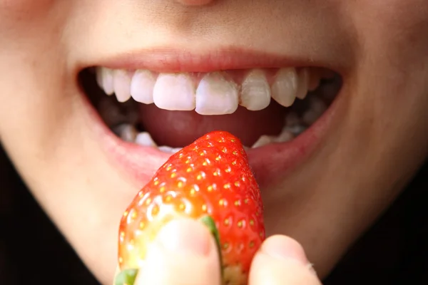 女孩把草莓放到她嘴里吃 — 图库照片