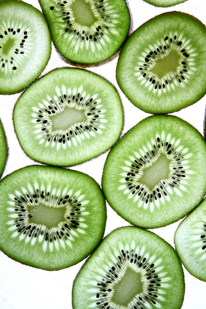 Detail view of kiwi slices backlighted over white background.