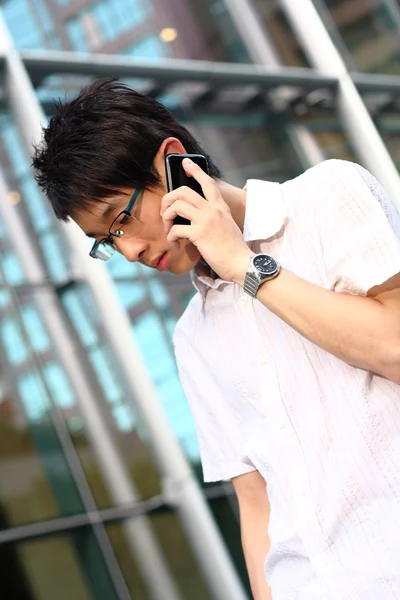Cep telefonu mod önünde tutan takım elbiseli genç işadamı — Stok fotoğraf