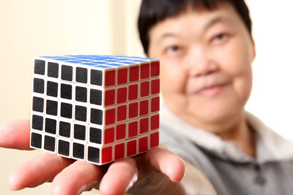 Vysocí čínští žena ukazují kompletní Rubikova kostka — Stock fotografie