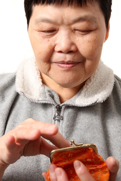 Старшая китаянка берет деньги из сумки — стоковое фото