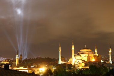 Illuminated Hagia Sophia and some beams (national holiday) in Istanbul at night clipart