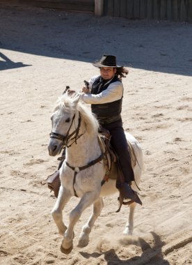 Deputy Sheriff firing his gun on horseback clipart