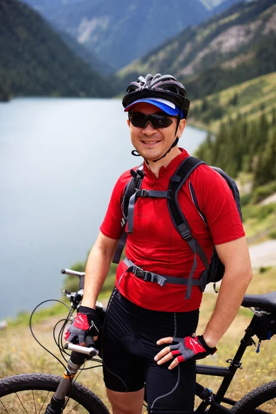 Radfahrer neben einem schönen Bergsee — Stockfoto