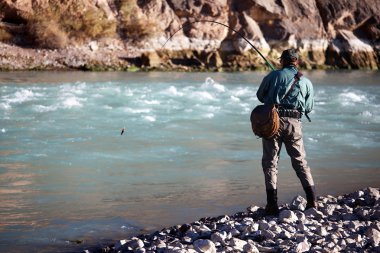 Fishing on mountain river clipart