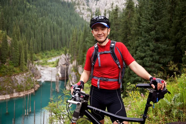 Ciclista de montaña asiática y lago — Foto de Stock