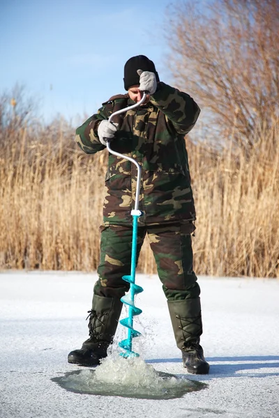 Fisherman drill on winter lake — Stock Photo, Image