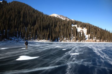 kar blizzard ve dağ göl kenarında bir adam