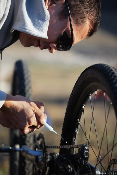 Motorlu bisiklet zincirini yağlamak — Stok fotoğraf