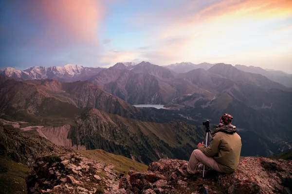 Fotógrafo nas montanhas ao pôr-do-sol — Fotografia de Stock