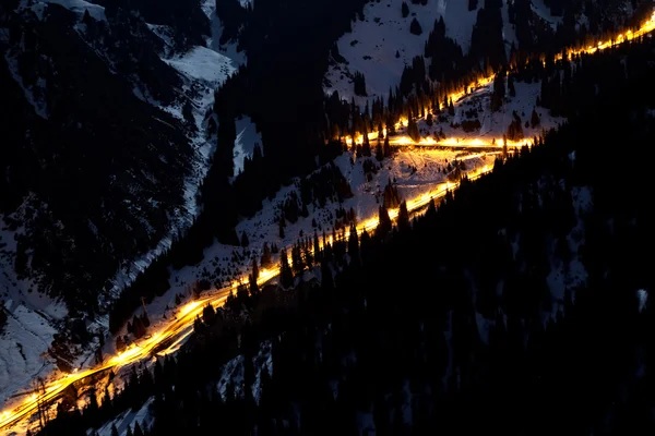 Ночная дорога в зимних горах — стоковое фото