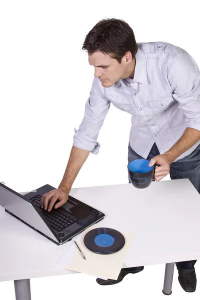Mladý muž, pití kávy a pracují na notebooku — Stock fotografie