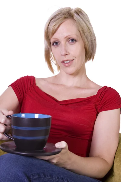 Mulher sentada em uma cadeira bebendo café — Fotografia de Stock