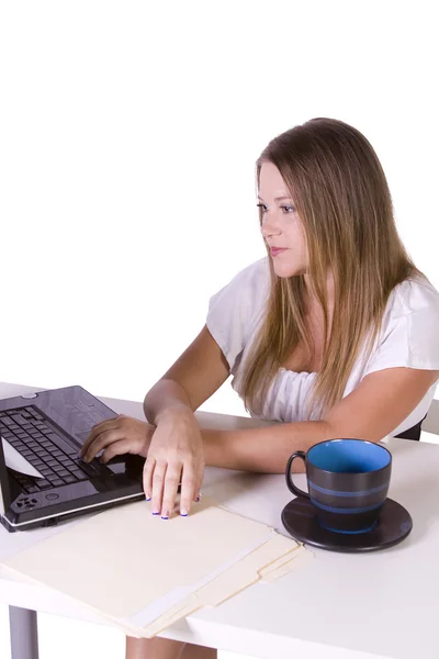 与杯咖啡她桌上的笔记本电脑上工作的女商人 — 图库照片